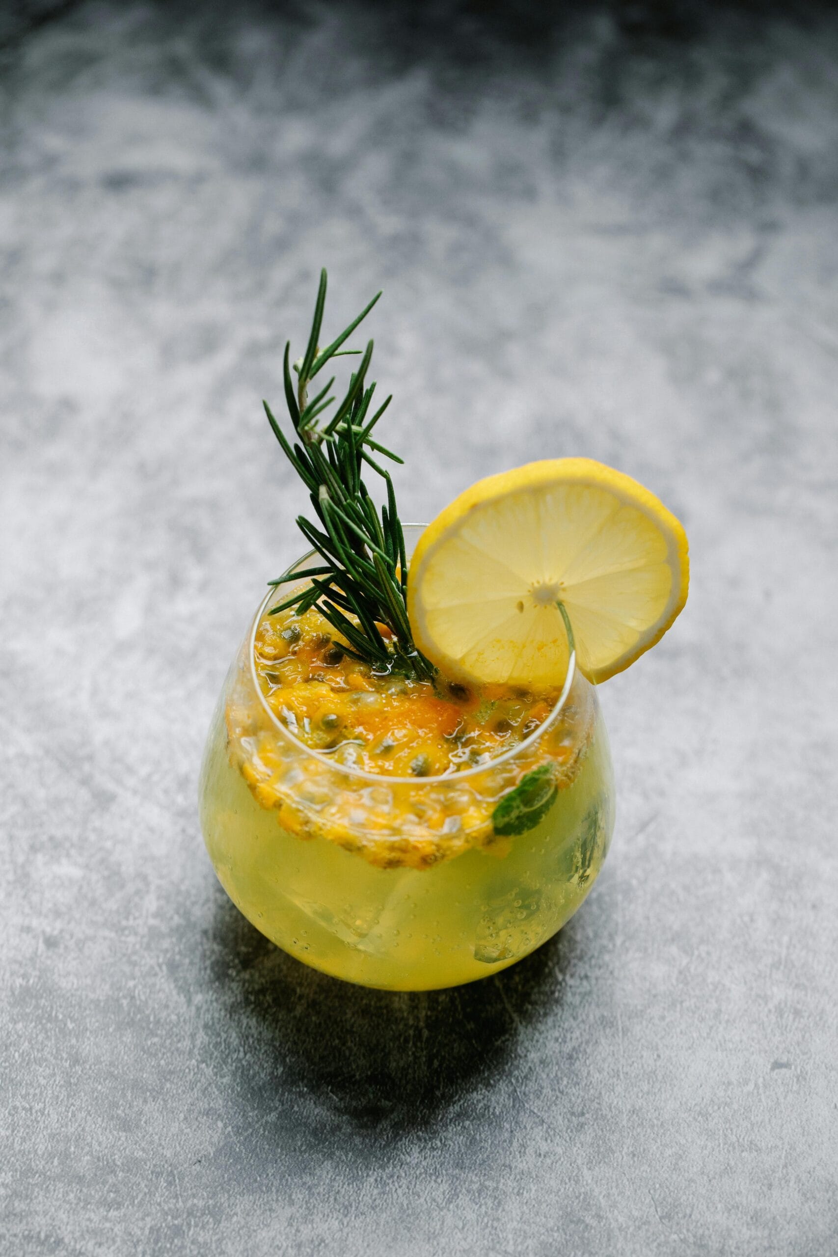 A refreshing lemon and rosemary cocktail served in a glass, perfect for a summer drink.